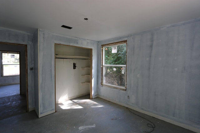unfurnished bedroom featuring a closet and unfinished concrete flooring