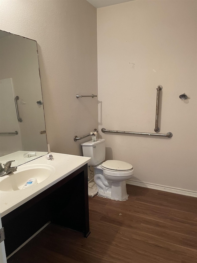 bathroom featuring toilet, vanity, and hardwood / wood-style flooring