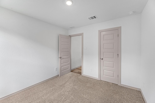 unfurnished bedroom featuring baseboards, visible vents, and carpet floors