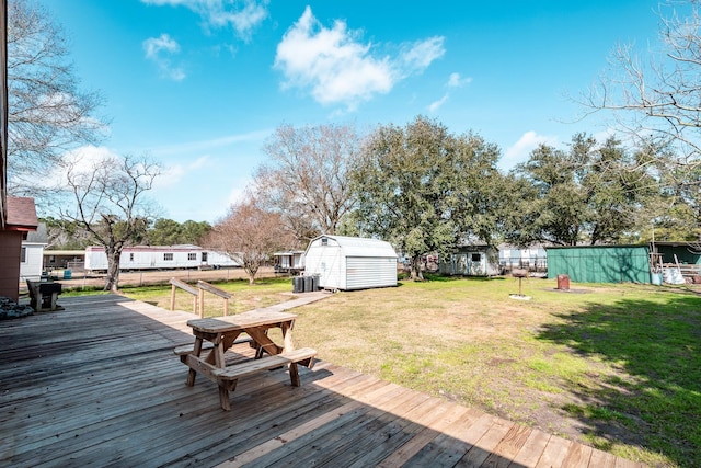 wooden deck with a lawn and a storage unit