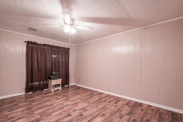 spare room with hardwood / wood-style flooring, ornamental molding, ceiling fan, and a textured ceiling