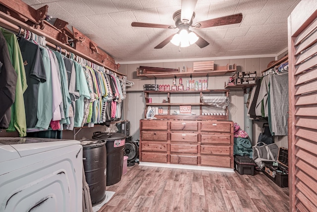 walk in closet featuring ceiling fan, washer / dryer, and light hardwood / wood-style flooring