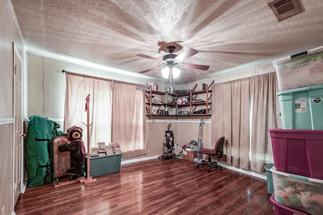 miscellaneous room featuring ceiling fan, dark wood-type flooring, and a textured ceiling