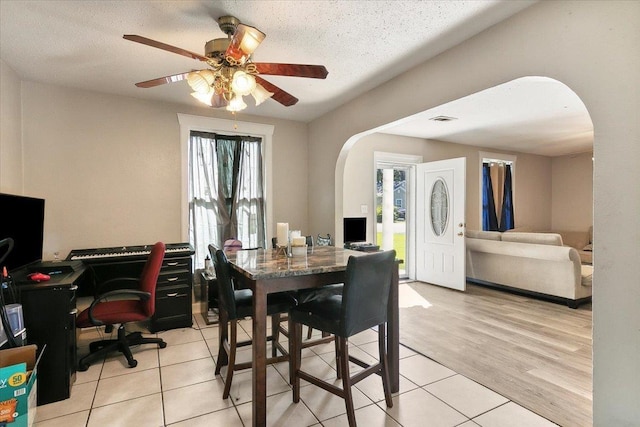 dining space with a textured ceiling, light hardwood / wood-style flooring, and ceiling fan