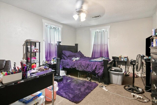 bedroom with carpet, a textured ceiling, and ceiling fan