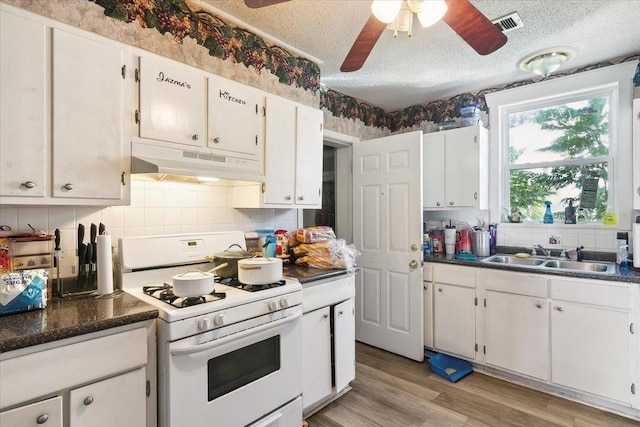 kitchen featuring a textured ceiling, ceiling fan, sink, white cabinetry, and white gas stove