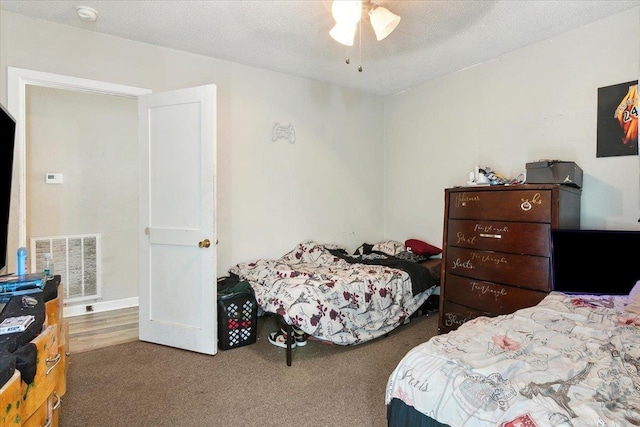 bedroom featuring ceiling fan, carpet, and a textured ceiling