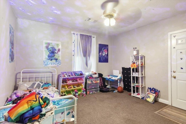 carpeted bedroom featuring ceiling fan and a textured ceiling