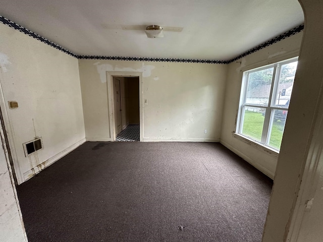 3123 13th St, Port Arthur, TX 77642 - unfurnished room with dark colored carpet, baseboards, and arched walkways