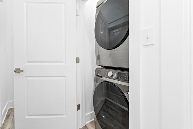 clothes washing area with stacked washer and dryer and light hardwood / wood-style floors