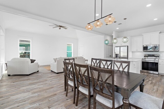 dining space featuring sink, light hardwood / wood-style flooring, and ceiling fan