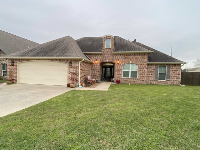 view of front facade featuring driveway, brick siding, and a front yard