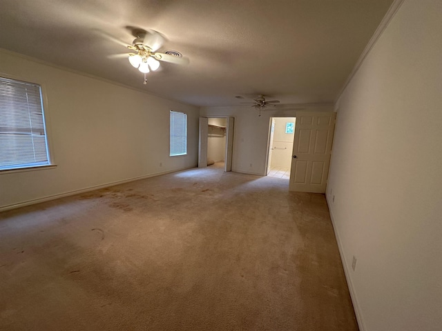 carpeted empty room featuring ceiling fan and crown molding