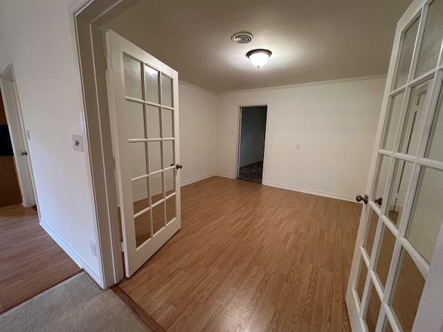 unfurnished room with light wood-type flooring and french doors