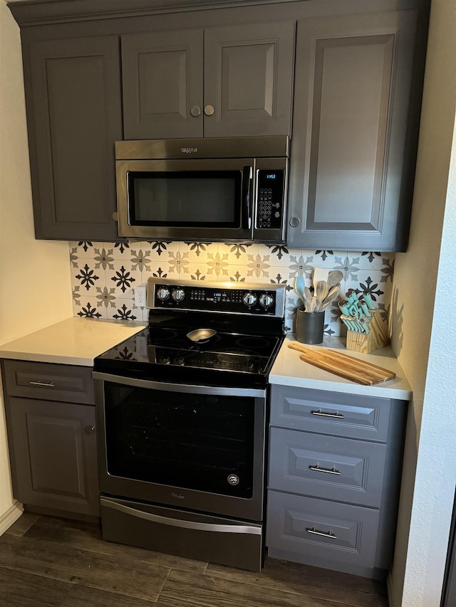 kitchen featuring gray cabinetry, tasteful backsplash, stainless steel appliances, and dark hardwood / wood-style floors