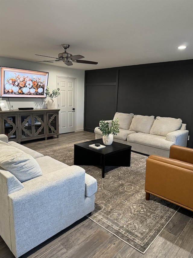 living room with dark hardwood / wood-style floors and ceiling fan