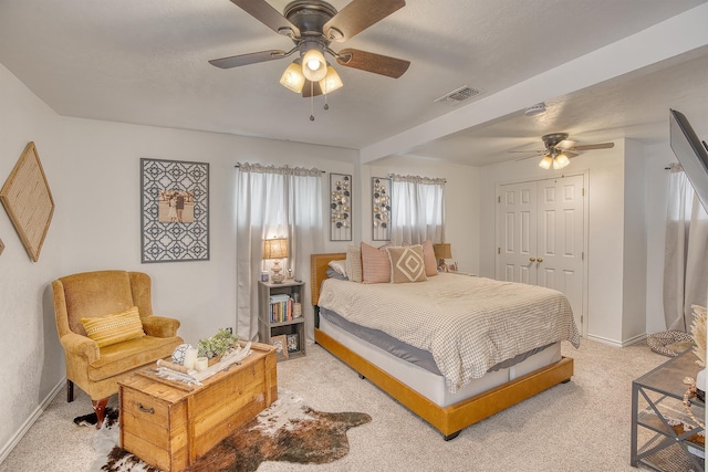 bedroom featuring visible vents, baseboards, light colored carpet, a closet, and a ceiling fan