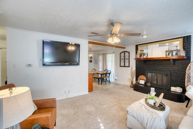 carpeted living room with baseboards, visible vents, a fireplace, ceiling fan, and a textured ceiling