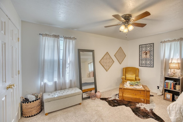 living area featuring baseboards, a healthy amount of sunlight, and carpet flooring