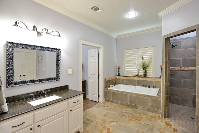 bathroom with visible vents, a garden tub, a tile shower, crown molding, and vanity