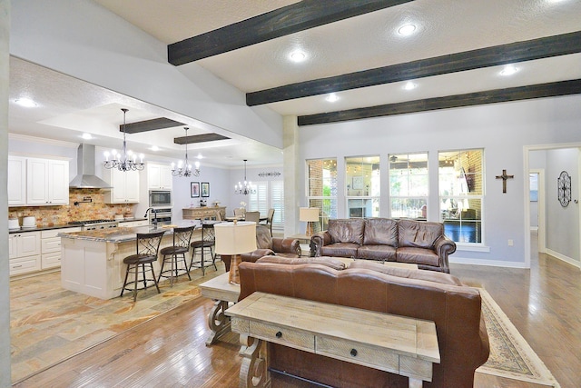 living area featuring light wood-type flooring, baseboards, and a chandelier