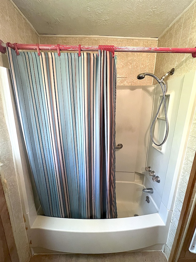 bathroom with shower / tub combo and a textured ceiling