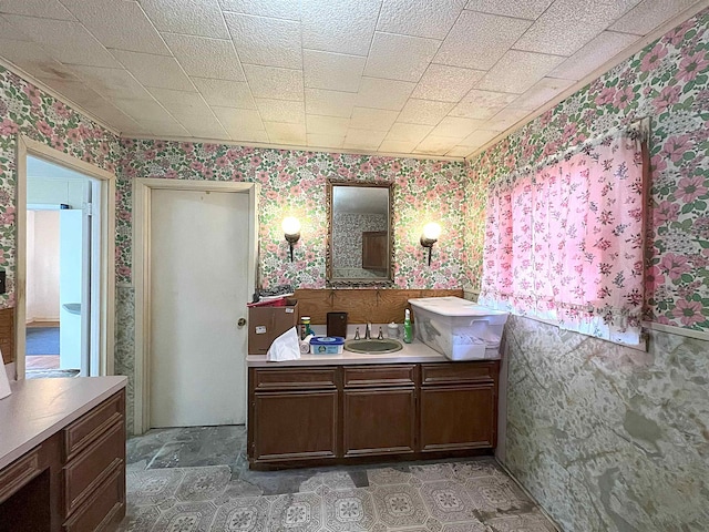 bathroom with wallpapered walls and a sink