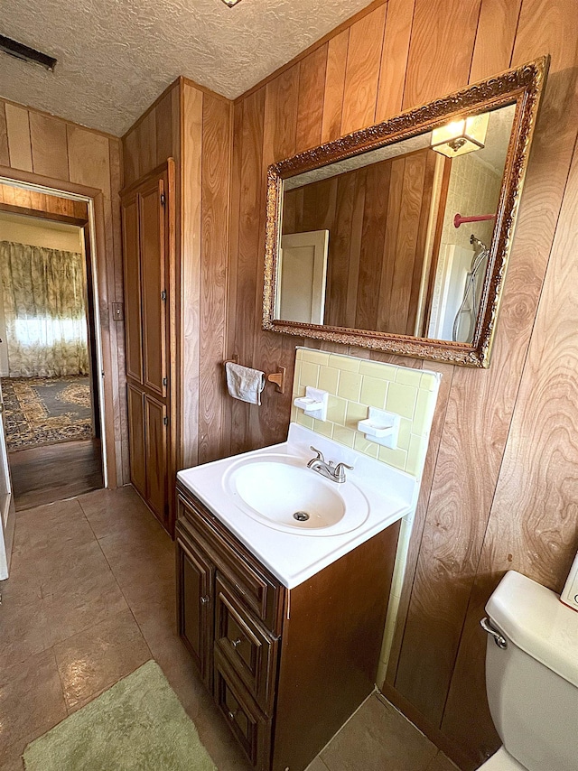 bathroom featuring visible vents, a textured ceiling, toilet, and vanity