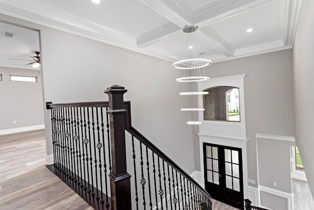 stairway with hardwood / wood-style flooring, a healthy amount of sunlight, beam ceiling, and coffered ceiling