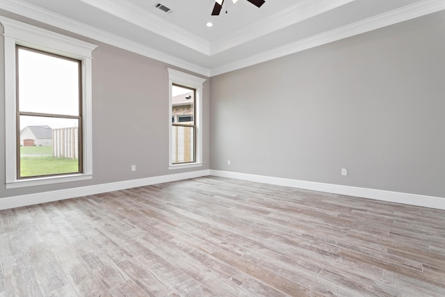 empty room featuring crown molding, light hardwood / wood-style flooring, a raised ceiling, and ceiling fan