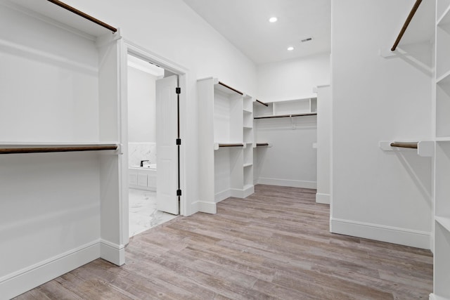 spacious closet featuring light hardwood / wood-style flooring