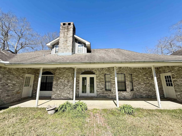 rear view of house with french doors, roof with shingles, and a patio area