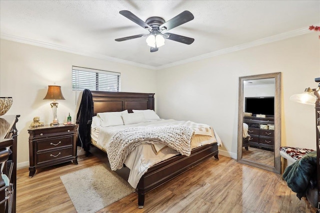 bedroom with ornamental molding, light wood-style flooring, baseboards, and a ceiling fan