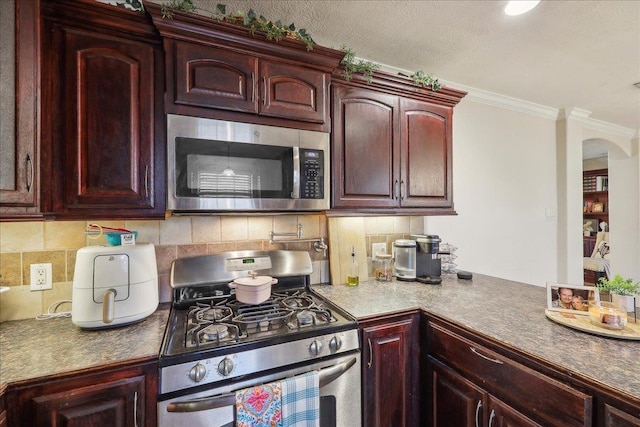 kitchen featuring ornamental molding, dark brown cabinets, appliances with stainless steel finishes, and tasteful backsplash