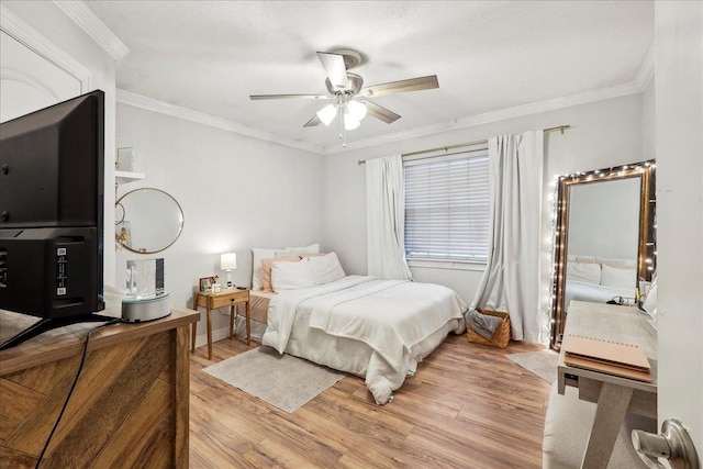 bedroom with light wood-style floors, ornamental molding, and a ceiling fan