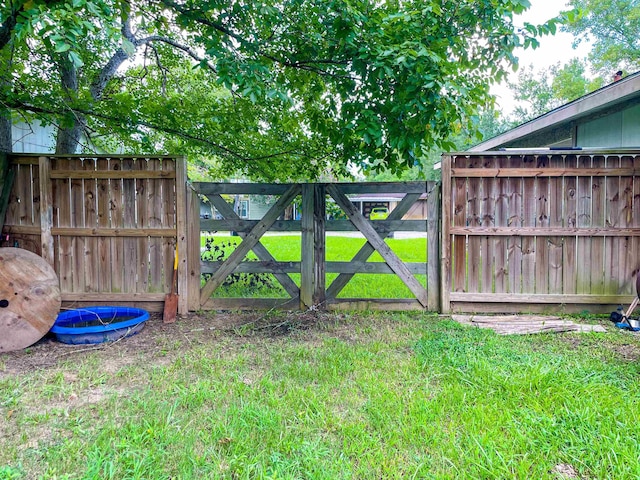 view of gate with a lawn