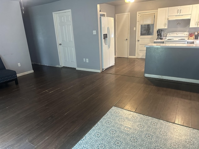 3104 Main Ave, Groves, TX 77619 - kitchen featuring white appliances, under cabinet range hood, dark wood-type flooring, light countertops, and white cabinetry