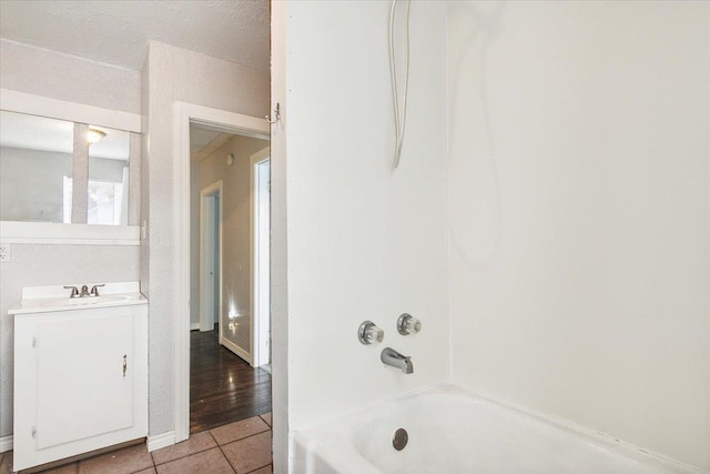 bathroom with tile patterned flooring, vanity, and shower / bathtub combination