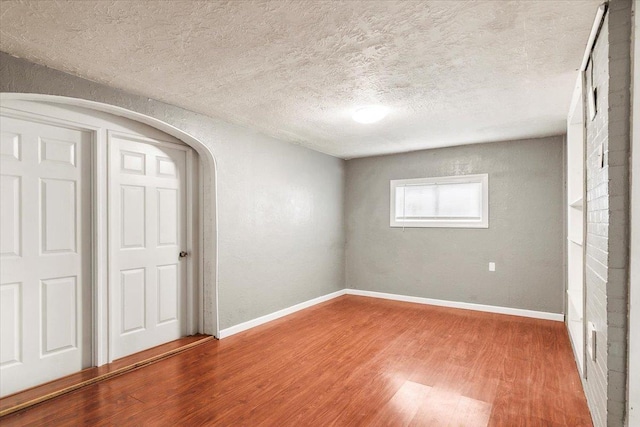 unfurnished bedroom with wood-type flooring and a textured ceiling