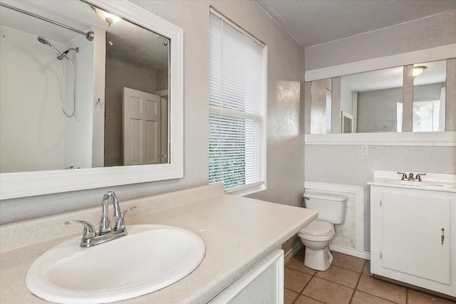 bathroom with a shower, tile patterned flooring, vanity, and toilet