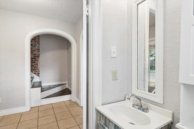 bathroom featuring tile patterned flooring, vanity, and a textured ceiling