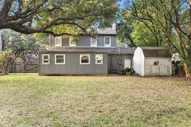 rear view of house featuring a lawn and a storage shed