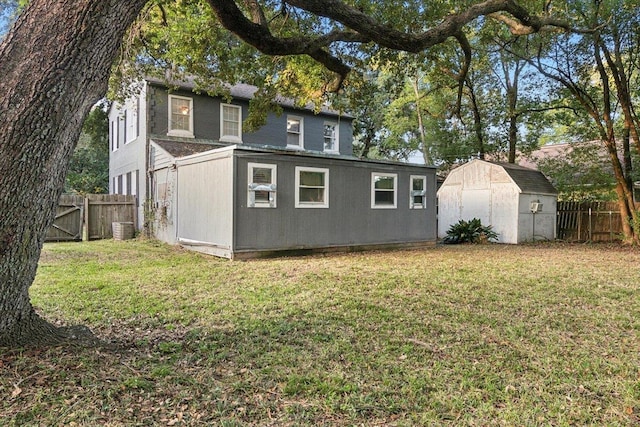 rear view of house with a yard, a shed, and cooling unit