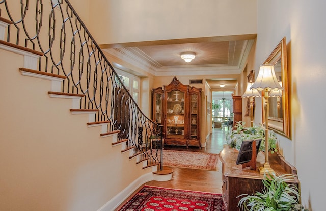 entryway with a healthy amount of sunlight, hardwood / wood-style flooring, and crown molding