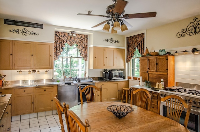 kitchen featuring backsplash, ceiling fan, light tile patterned floors, appliances with stainless steel finishes, and stainless steel counters