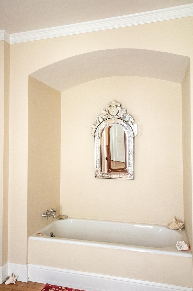 bathroom featuring a washtub, hardwood / wood-style flooring, and ornamental molding