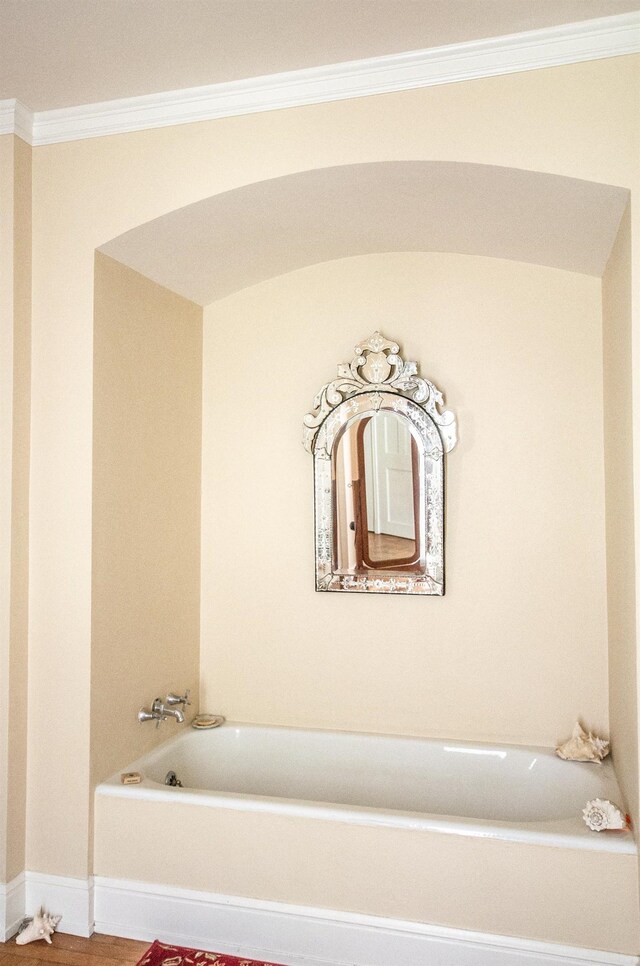 bathroom featuring a washtub, hardwood / wood-style flooring, and ornamental molding