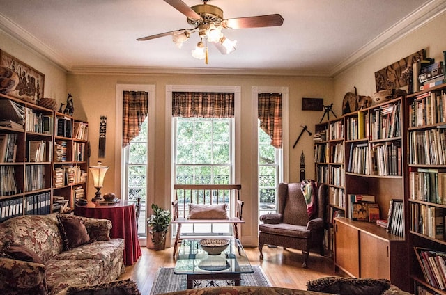 living area with ceiling fan, ornamental molding, and light hardwood / wood-style flooring