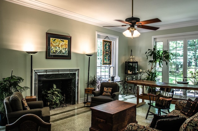 sitting room with crown molding, a high end fireplace, and ceiling fan