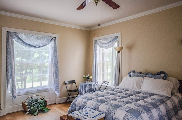 bedroom featuring light hardwood / wood-style floors, ceiling fan, and crown molding